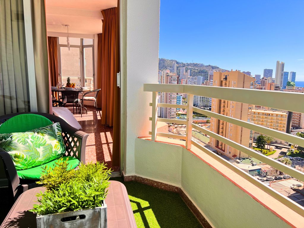 Zona de mesa y descanso en la terraza exterior abierta del apartamento en Benidorm